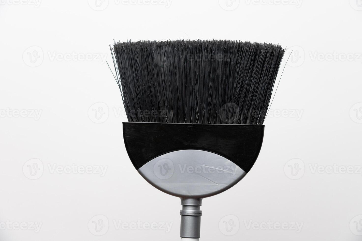 Gray plastic broom on white background with copy space. House cleaning concept photo
