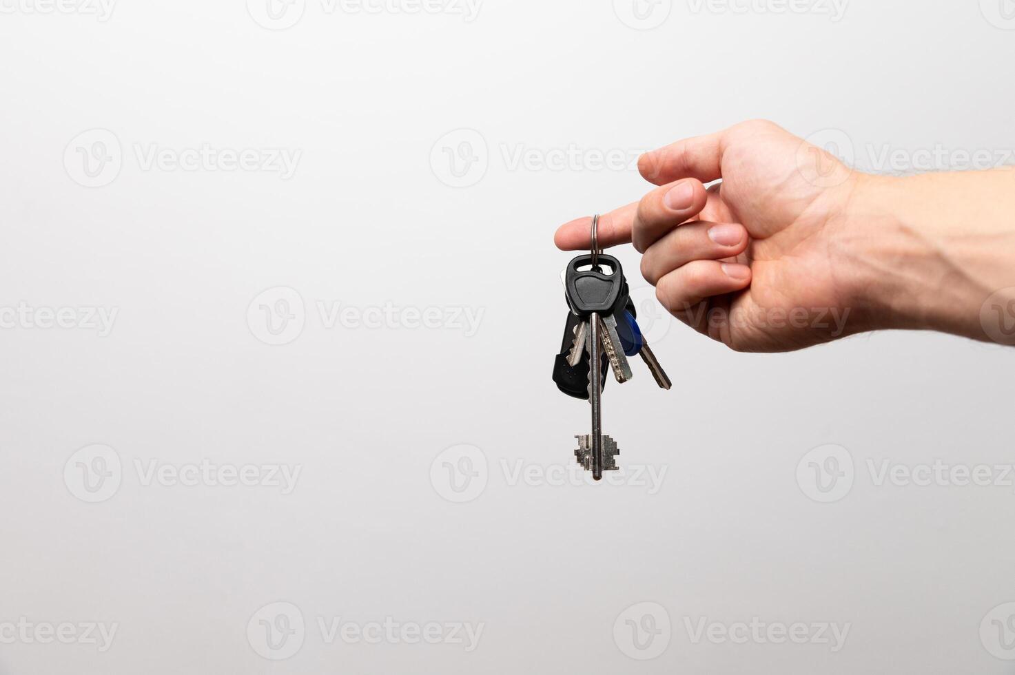 Female Hand holding key with a keychain in the shape of the house. House key on the white background photo