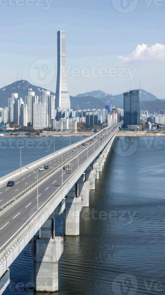 A bridge spanning over the water with a city in the background photo