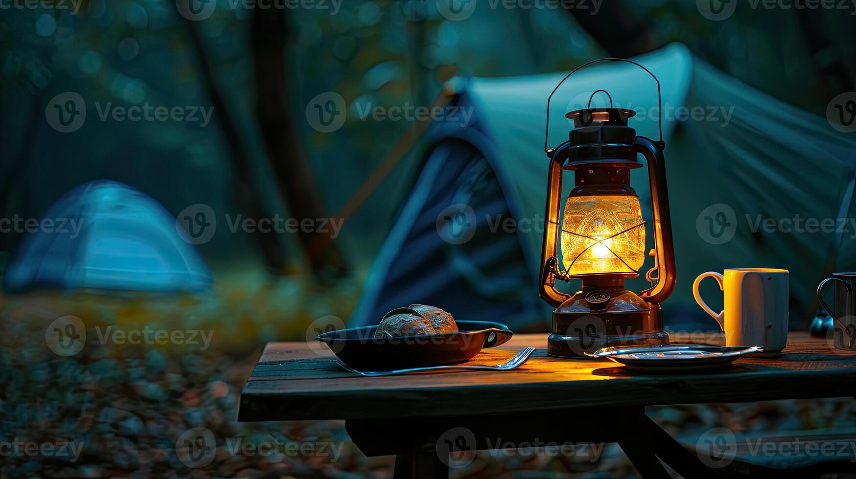 A campfire and a lantern sit on a table in the woods photo