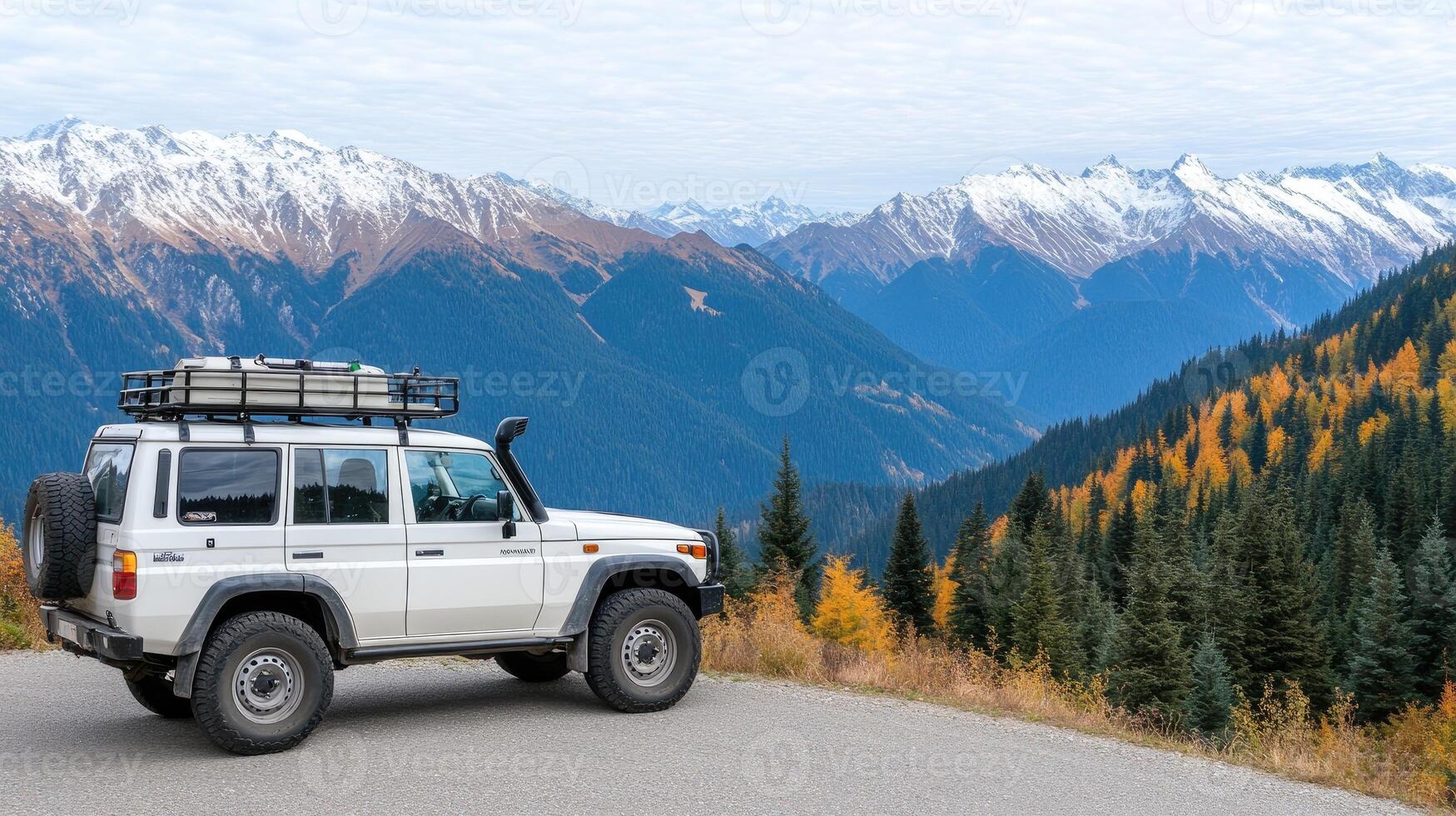 A white suv is parked on a mountain road with mountains in the background photo