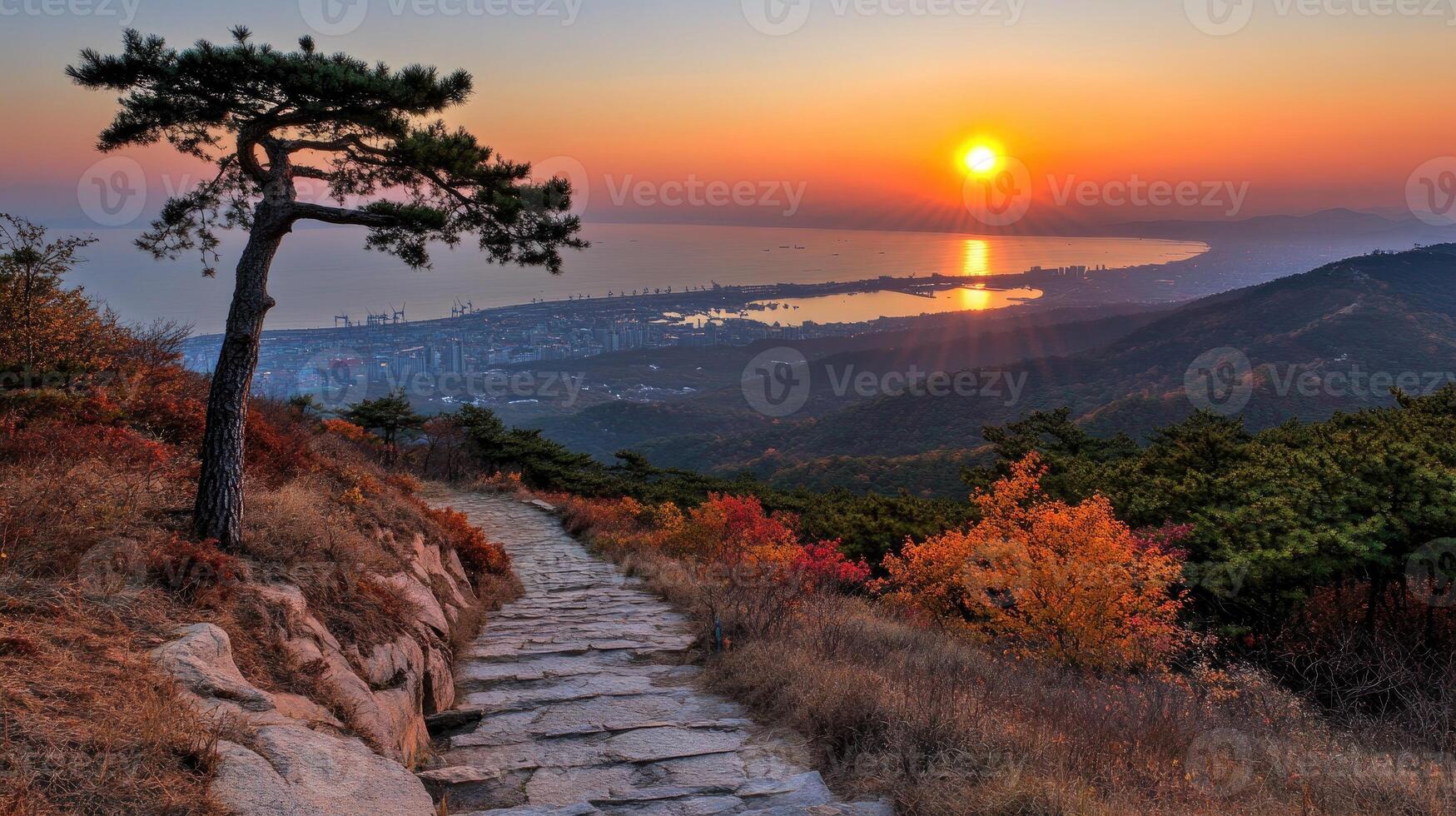 A path leading up to a mountain with the sun setting behind it photo
