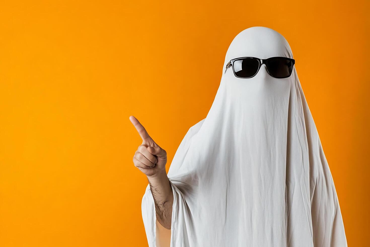 A person in a ghost costume with sunglasses and a white sheet photo