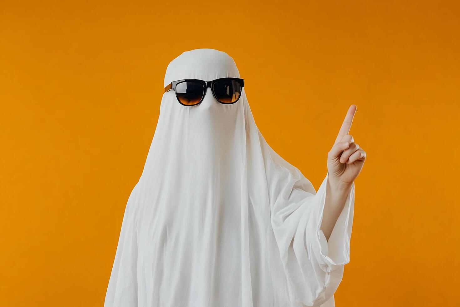 A person in a ghost costume with sunglasses and a white sheet photo