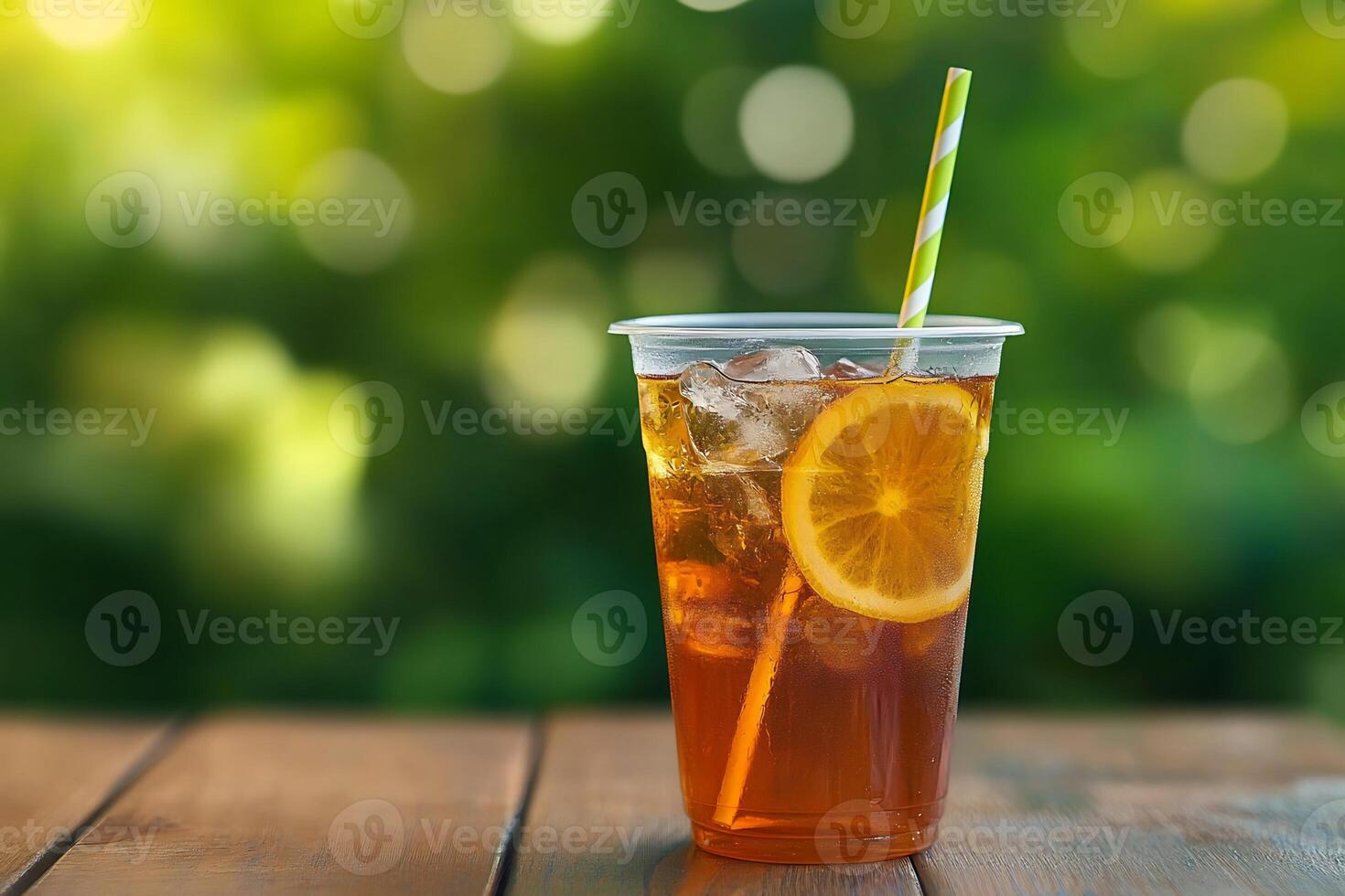 A glass of iced tea with a straw on a wooden table photo
