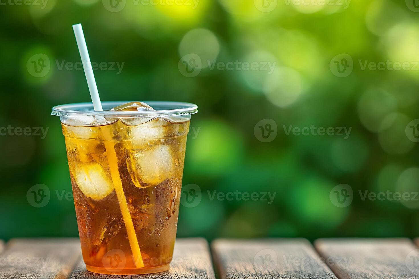 A glass of iced tea with a straw on a wooden table photo