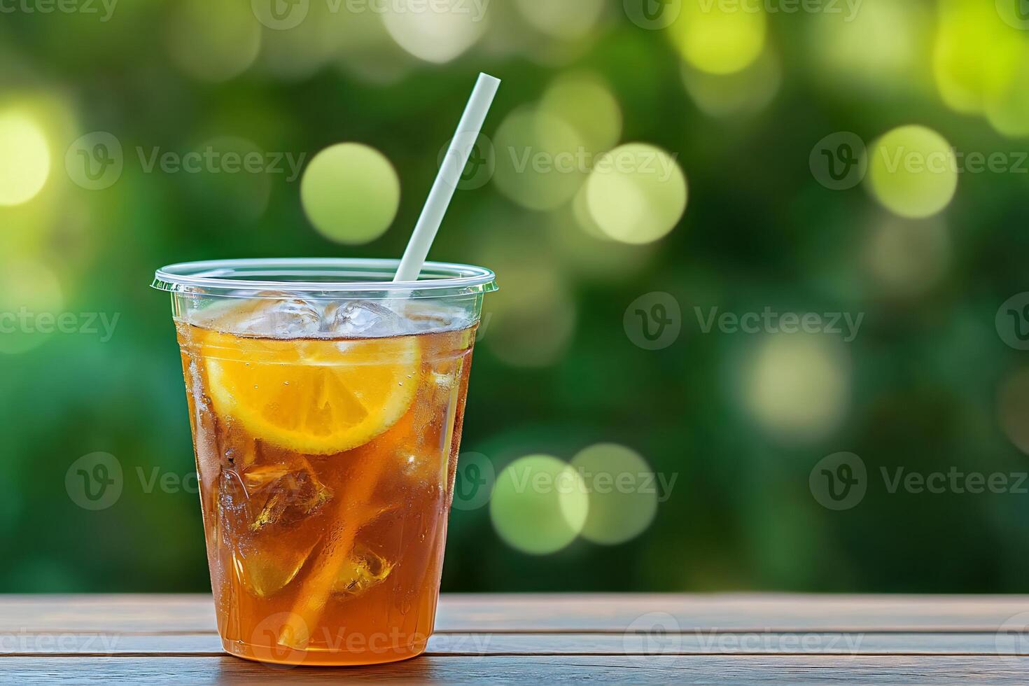 A glass of iced tea with a straw on a wooden table photo