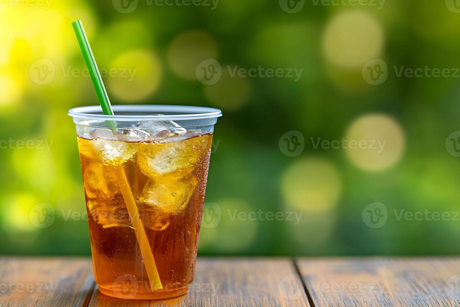 A cup of iced tea with a straw on a wooden table photo