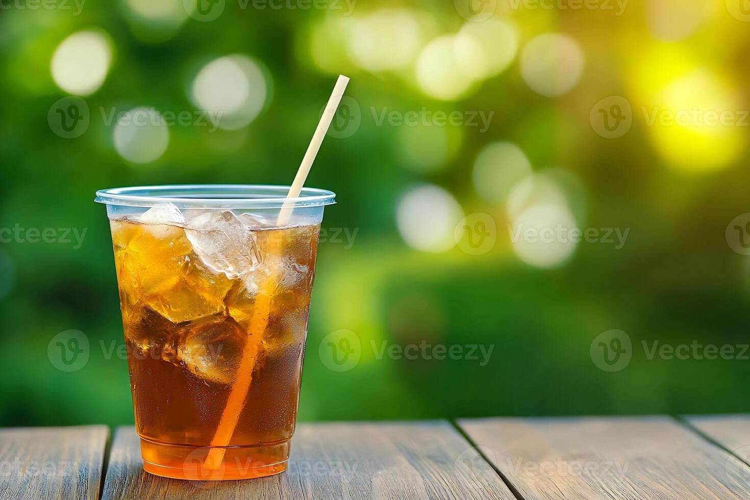 A glass of iced tea with a straw on a wooden table photo