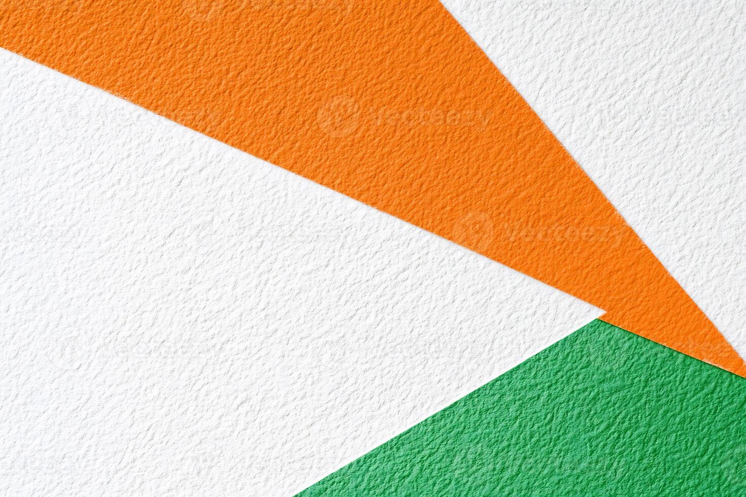 An orange, green and white triangle pattern on a white wall photo