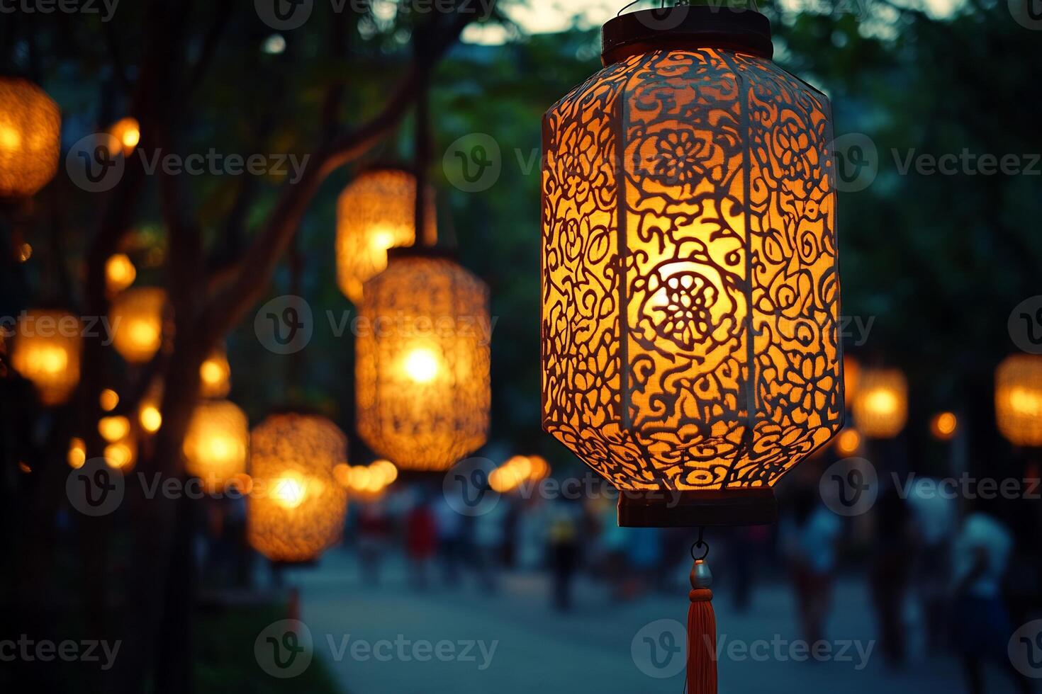 Chinese lanterns hanging from trees in the evening photo