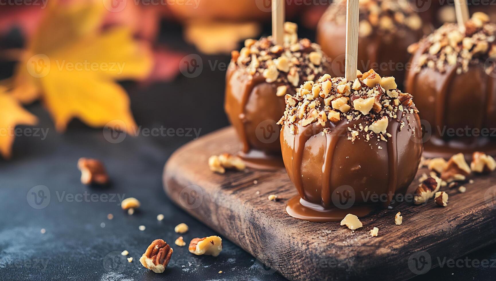 Caramel apples with nuts on a wooden board photo