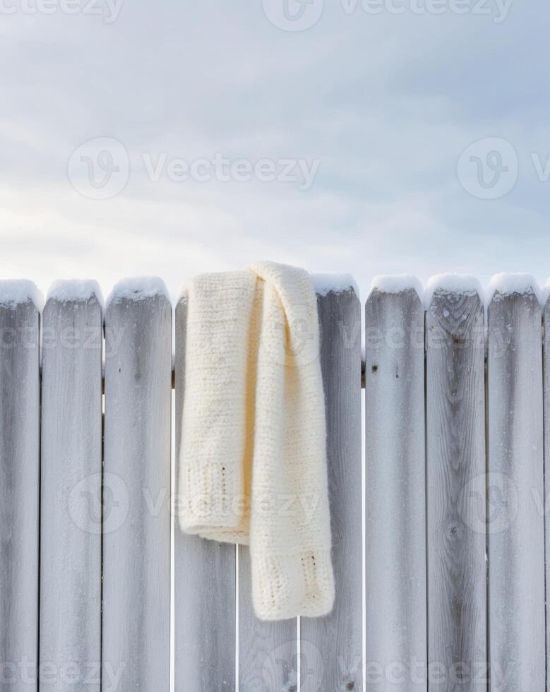 A white scarf is hanging on a fence photo