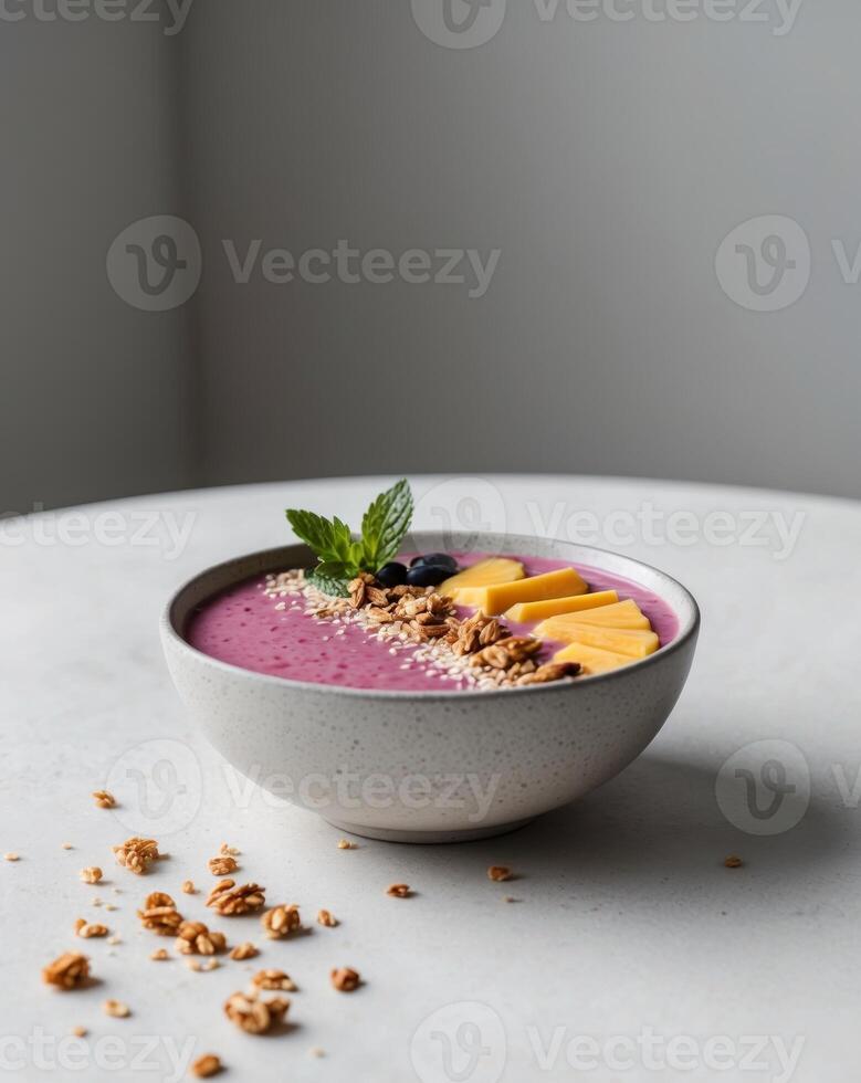 Tropical fruit smoothie bowl with granola and mint garnish photo
