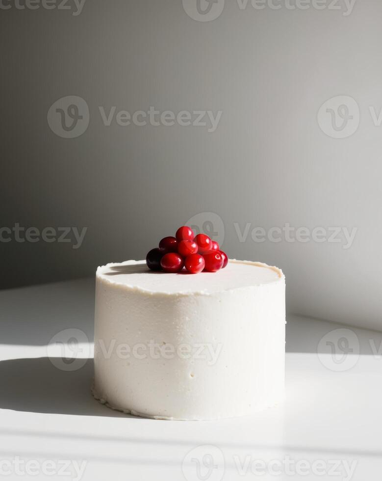 A white cake with a white frosting and red berries on top photo