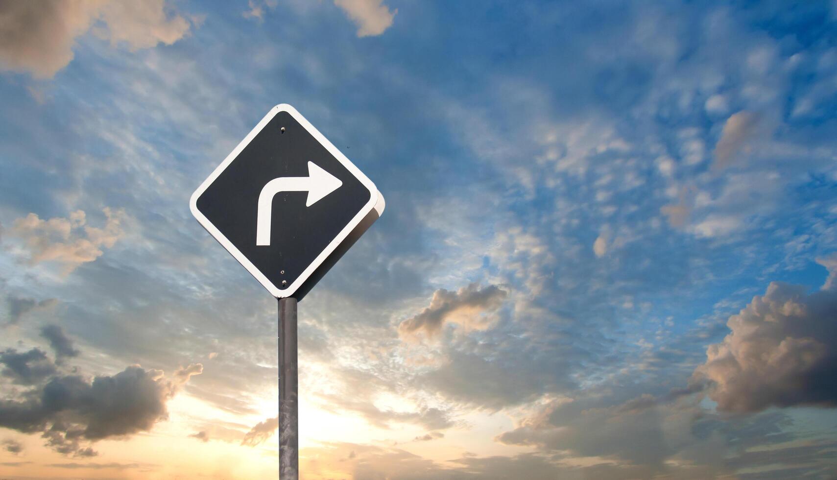 A road sign with a right turn arrow pointing to the sky photo