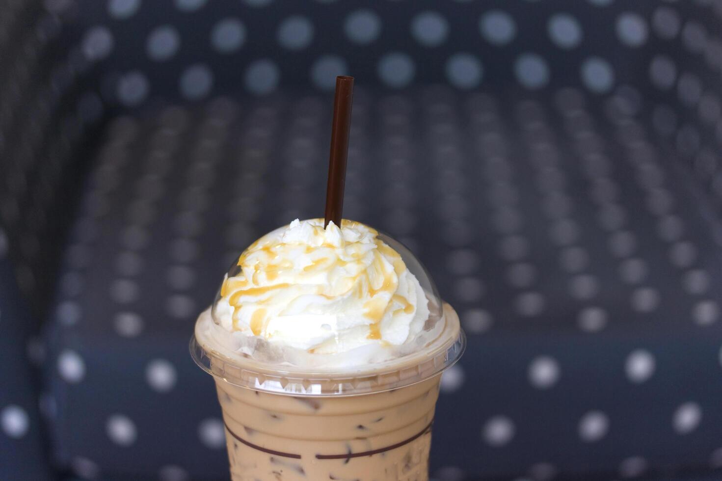 A cup of iced coffee with whipped cream and a chocolate bar photo