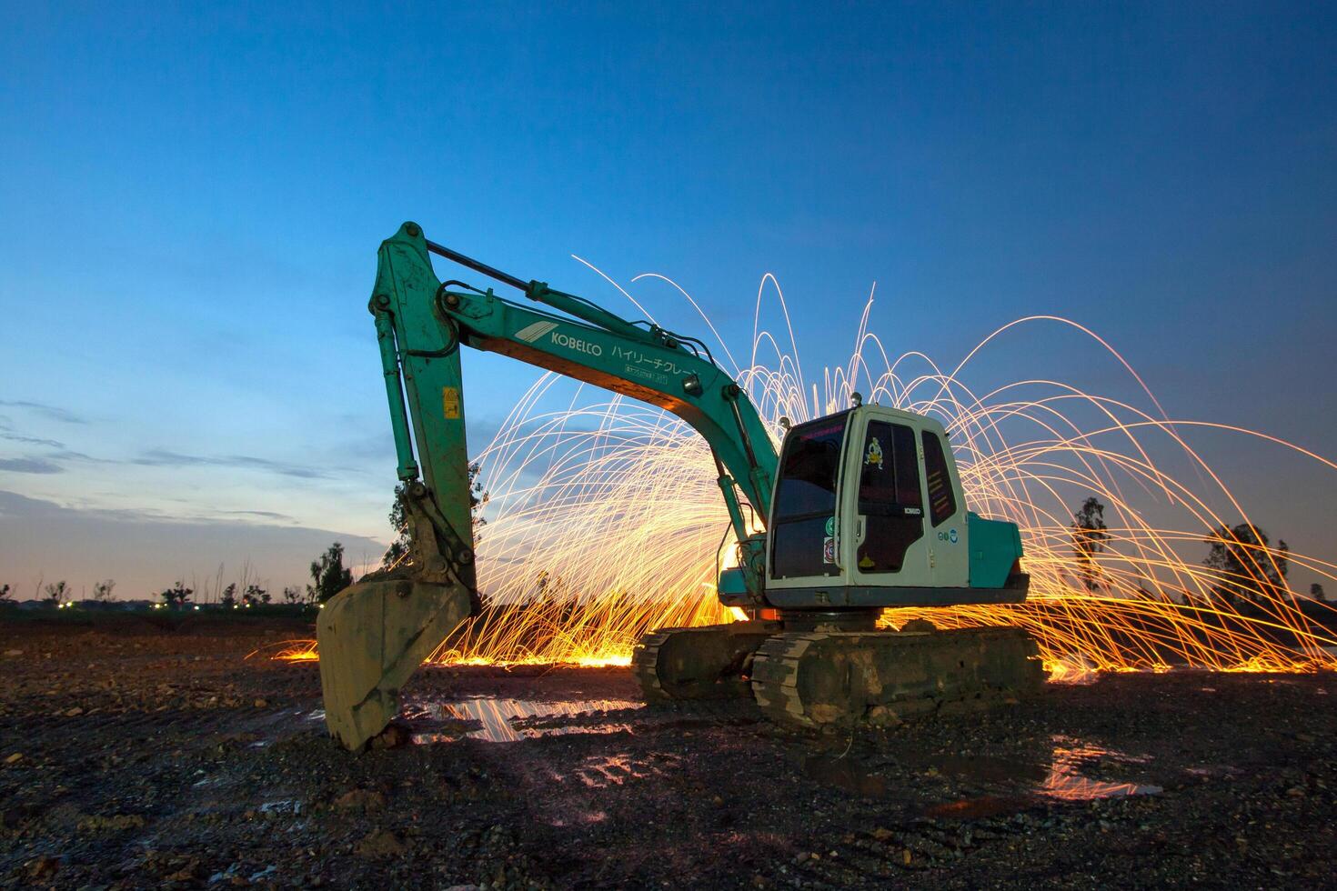 A construction machine is in the foreground with sparks photo