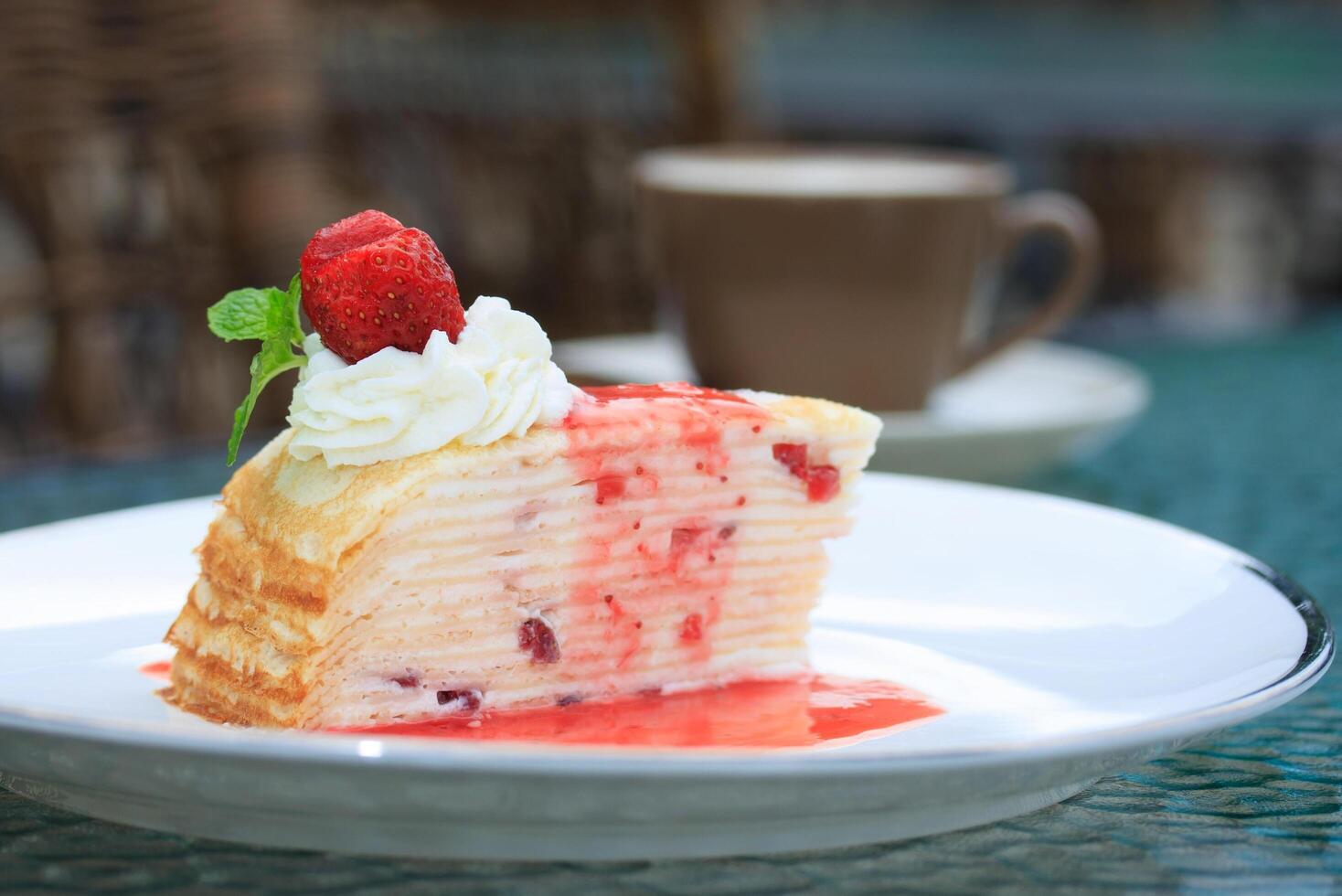 A piece of cake on a plate with a cup of coffee photo