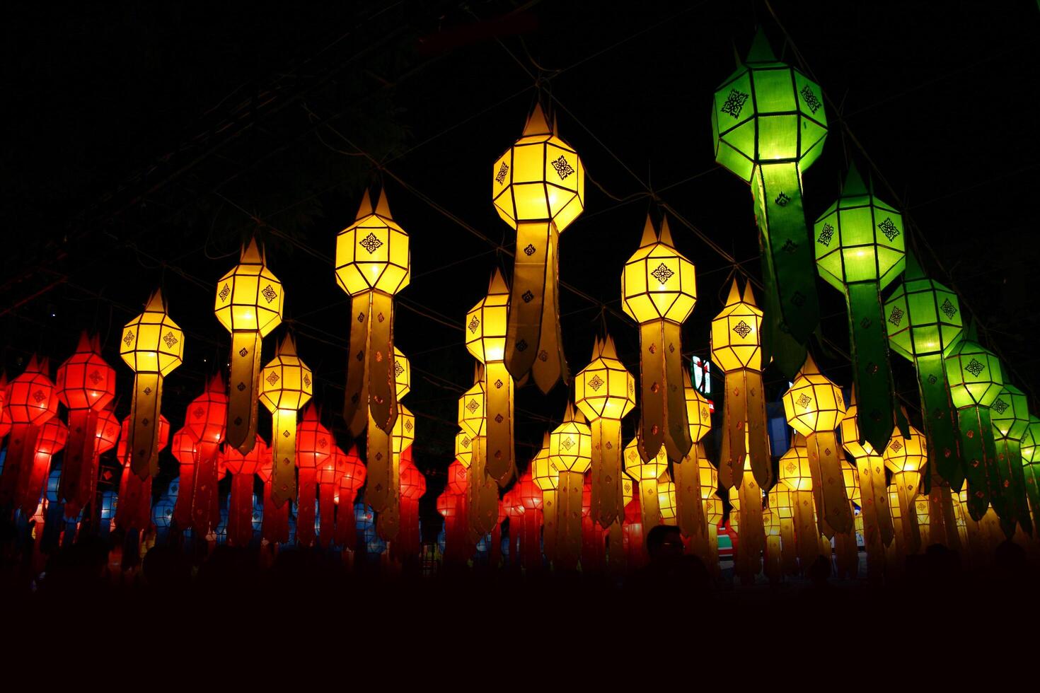 A group of colorful lanterns hanging from a ceiling photo