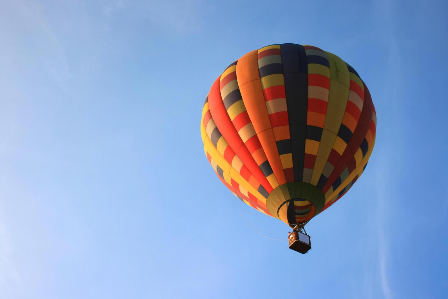 A colorful hot air balloon is flying in the blue sky photo