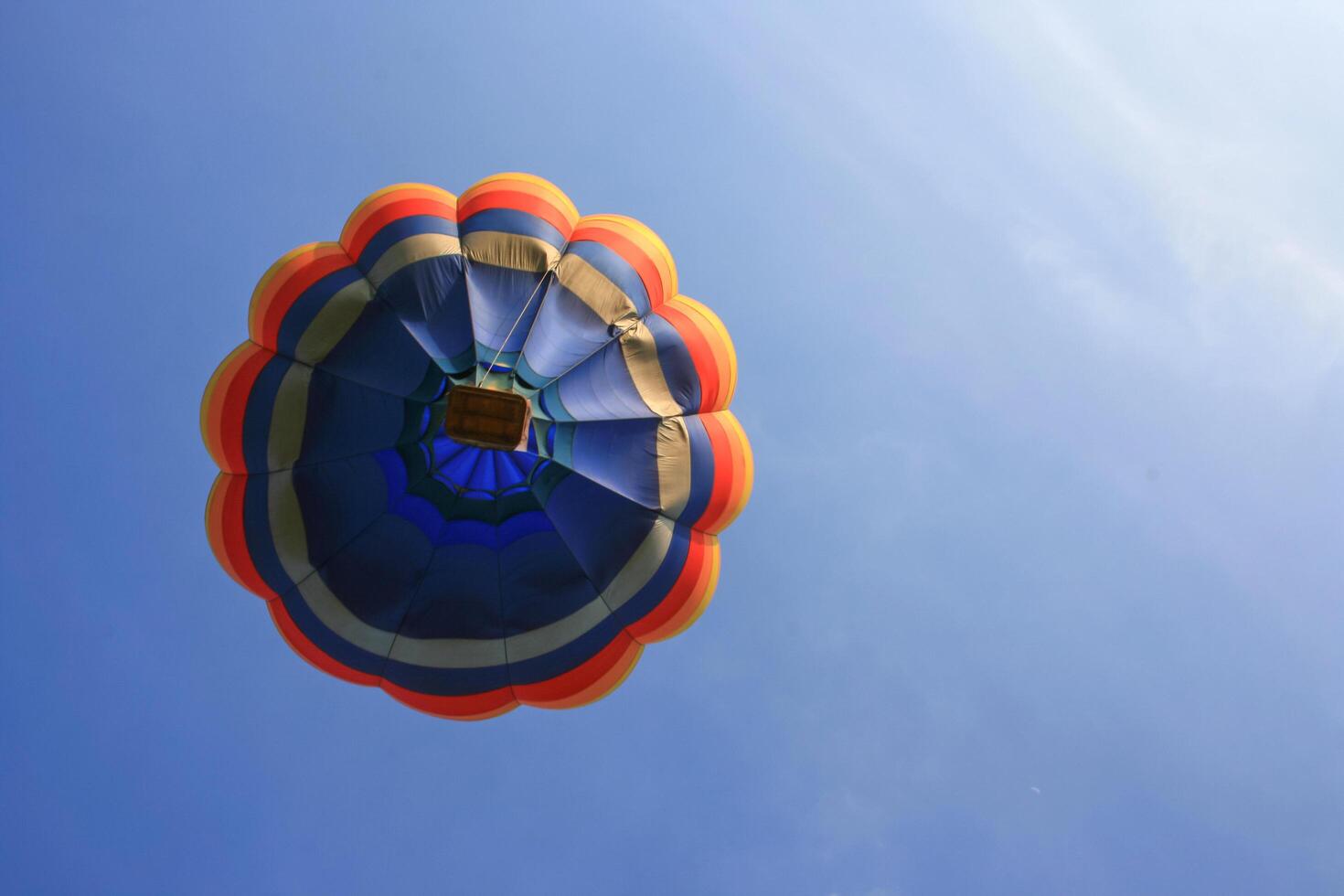 A colorful parachute is flying in the blue sky photo