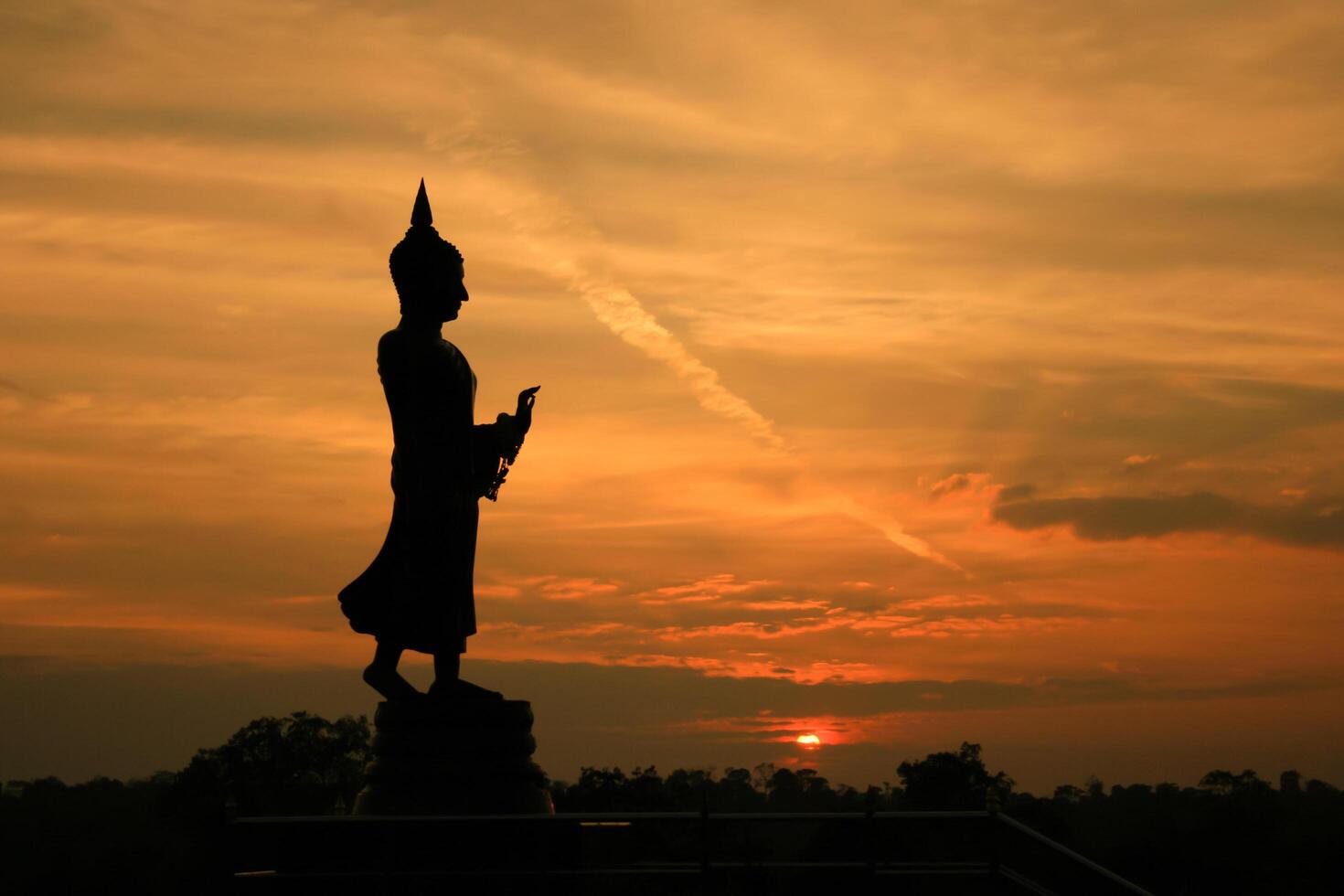 Silhouette of buddha statue at sunset photo