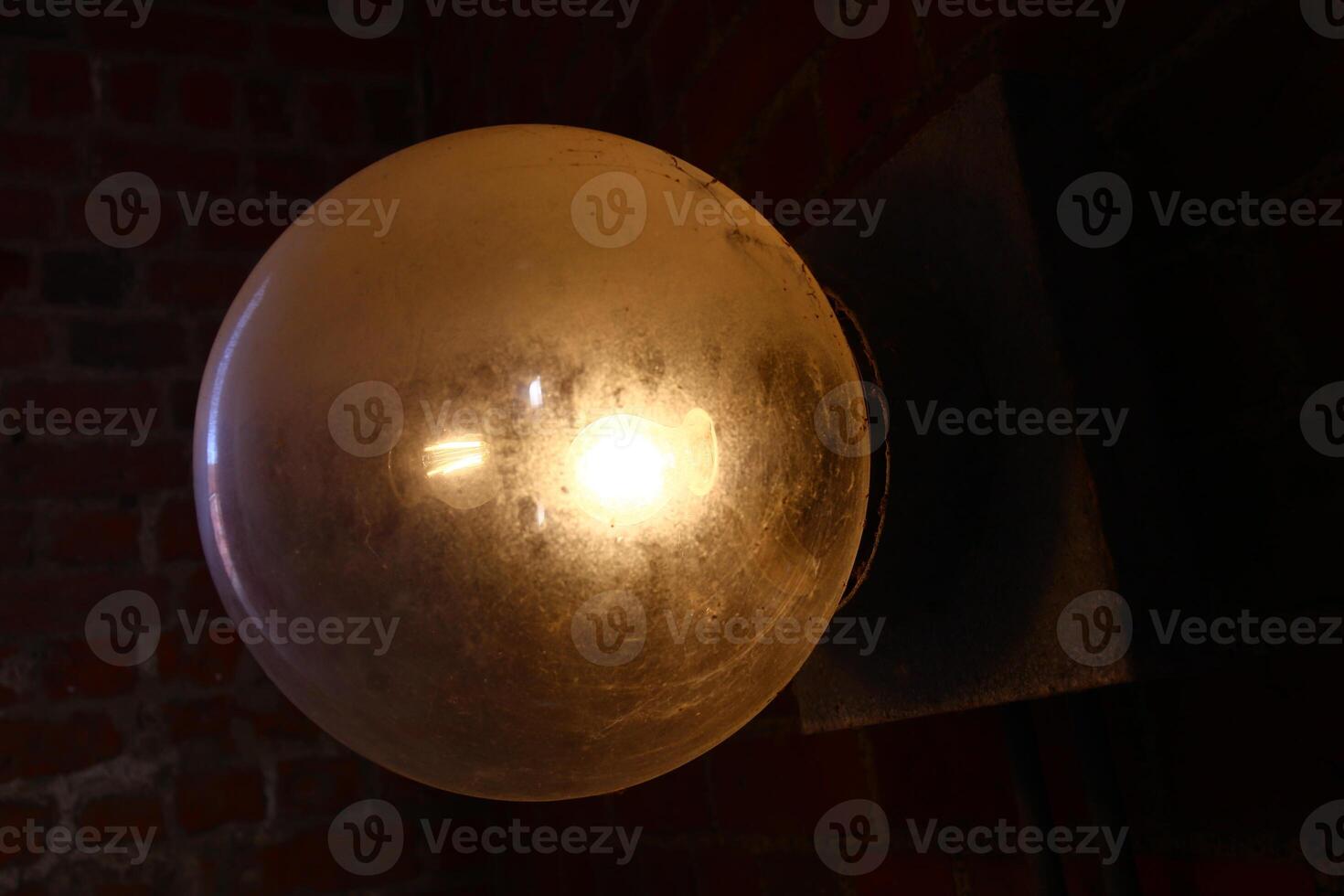 Old globe lamp made of glass with dark background photo