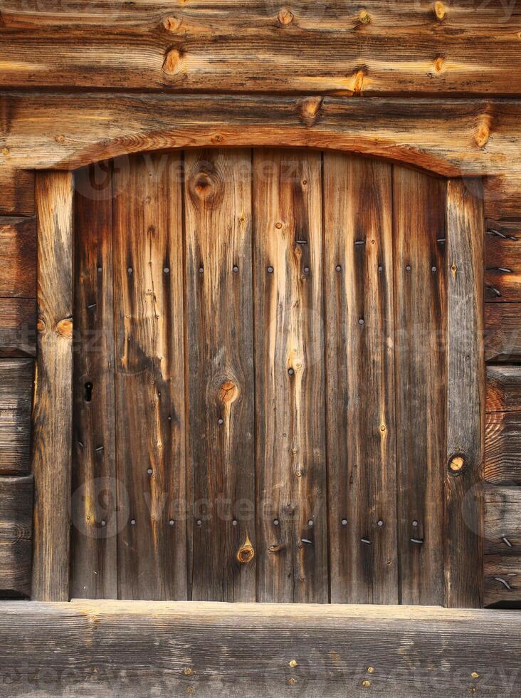 Old and rustic hatch on a log hut photo