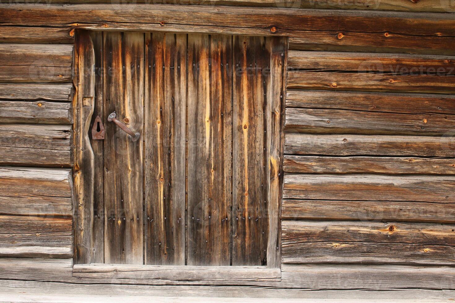 Old and rustic hatch on a log hut photo
