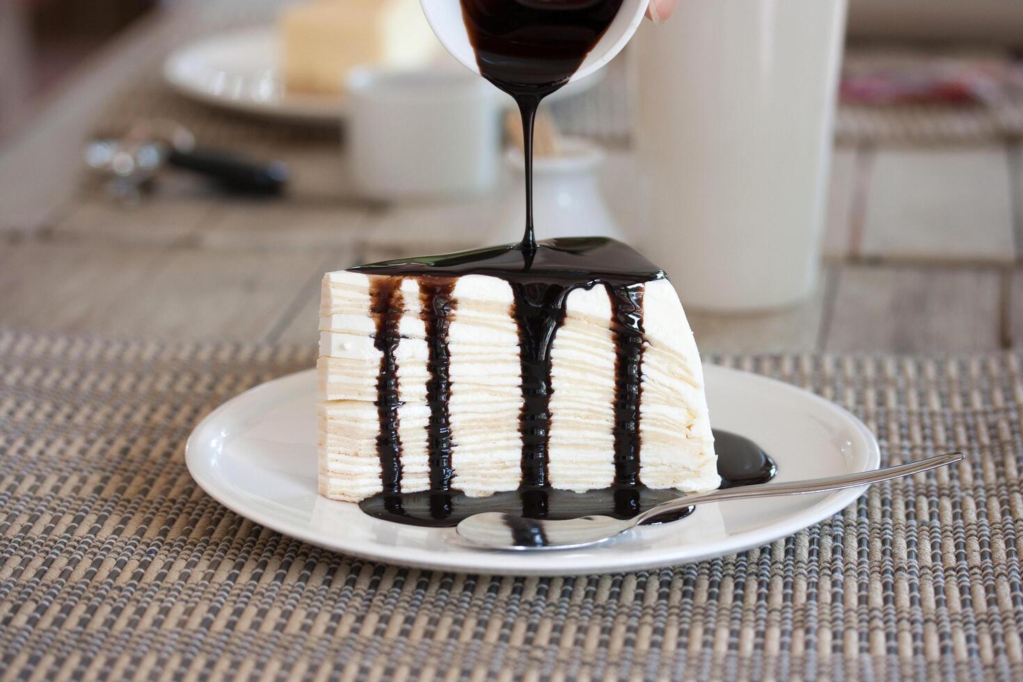 A piece of cake on a plate with a drizzle of chocolate sauce photo