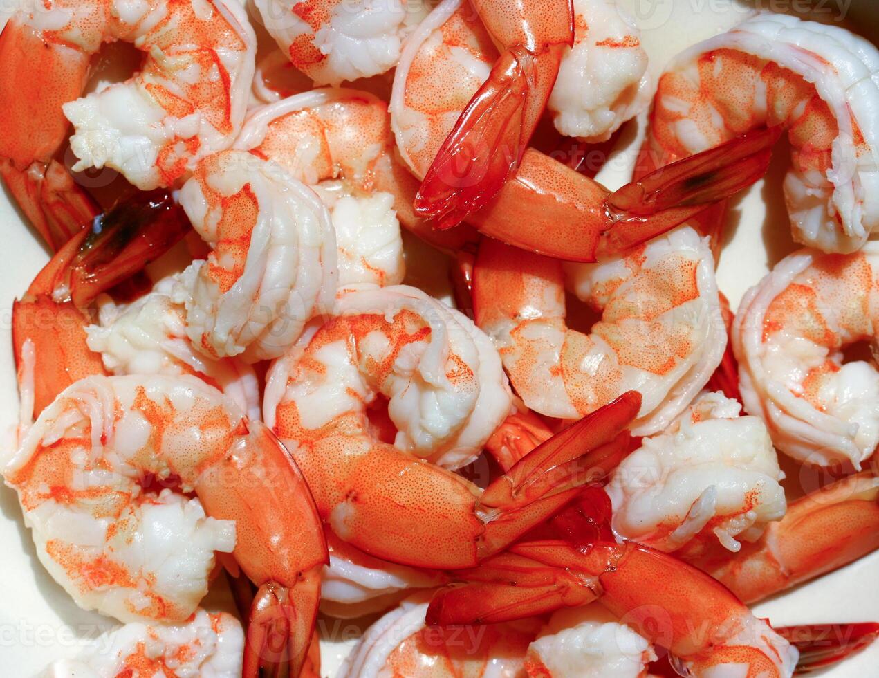 A bowl of cooked shrimp sitting on a table photo