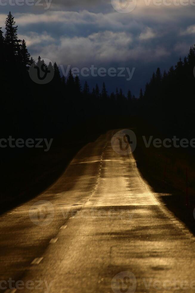 Conceptual image of Swedish road with golden reflections while the sky is dark blue photo