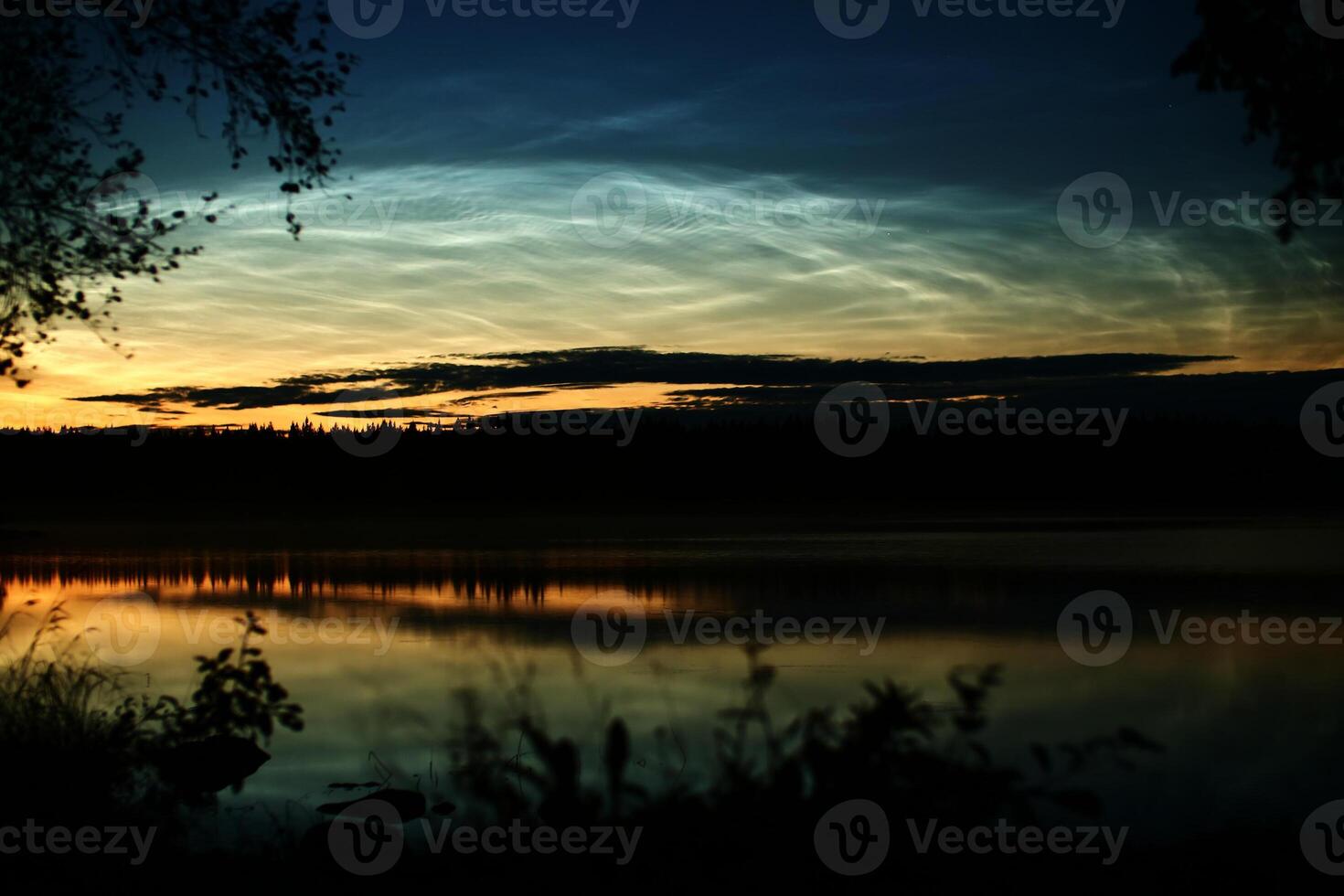 Illuminated cirrus clouds at dusk over lake Malgomaj in Vasterbotten, Sweden photo
