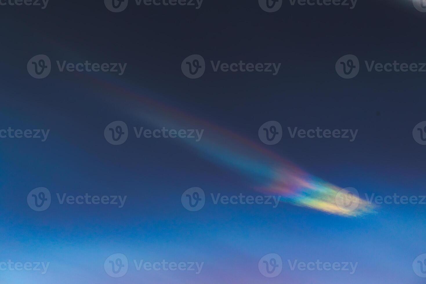 Nacreous cloud in dusk on a blue sky photo