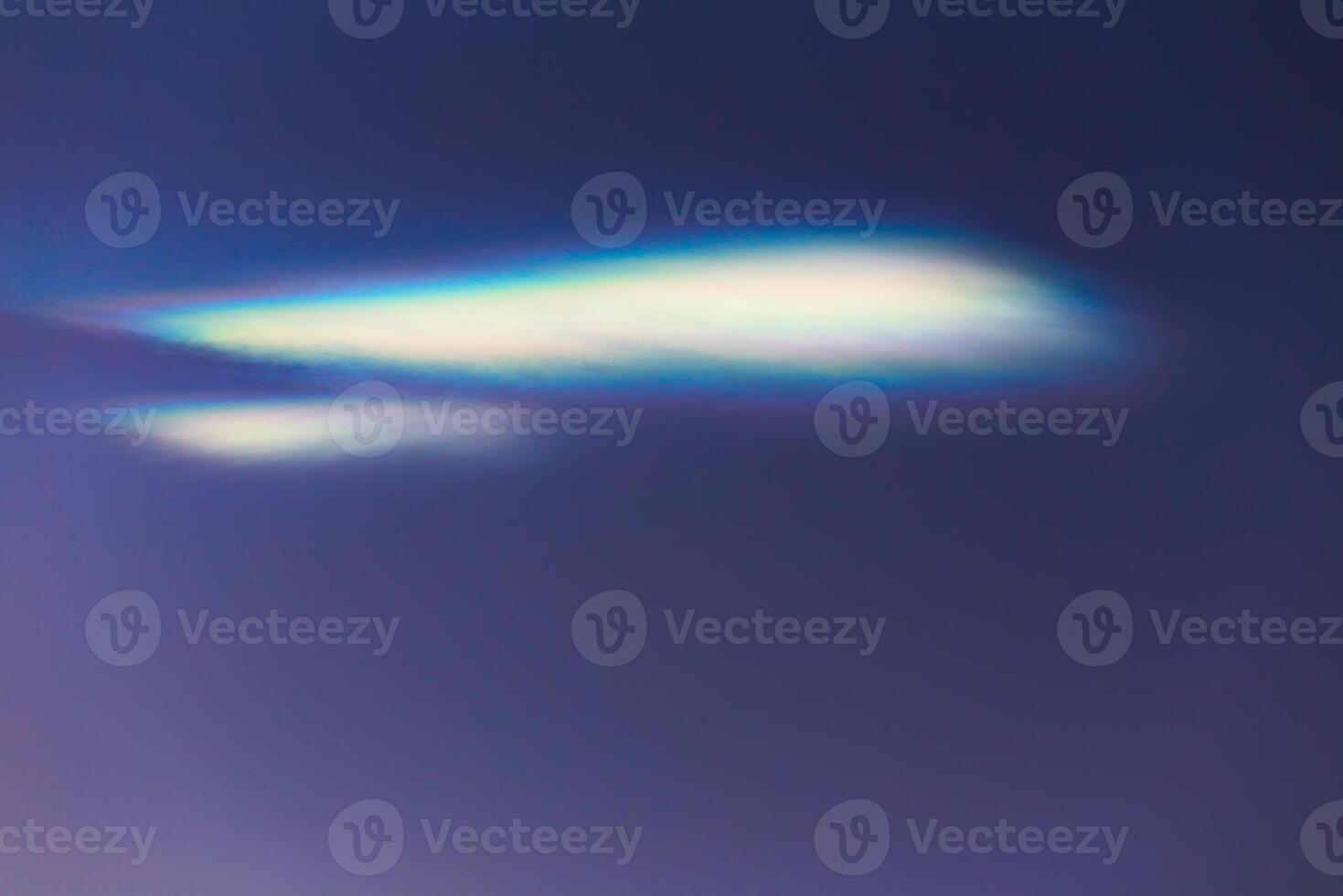 Nacreous cloud in dusk on a blue sky photo