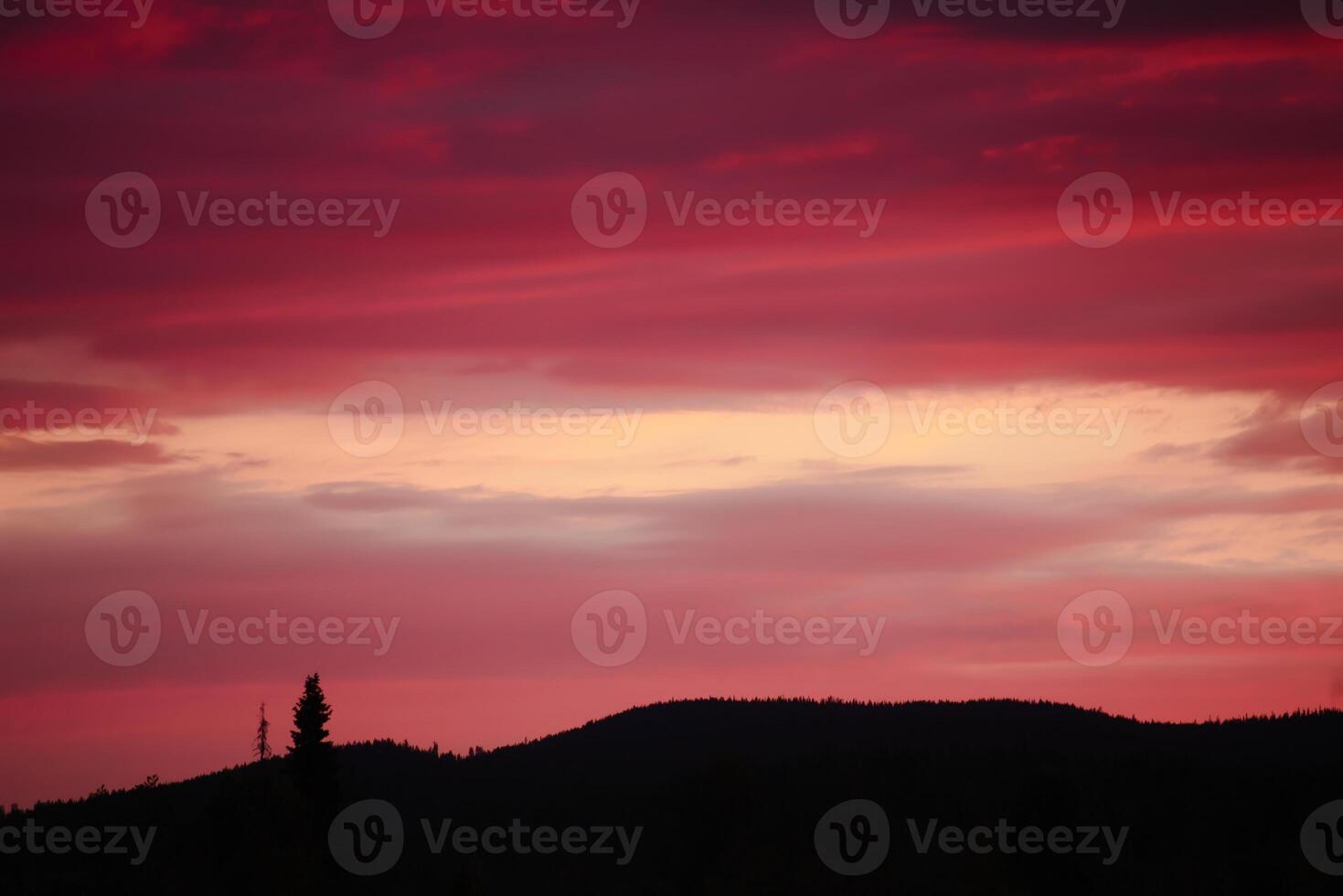 Impressive cloudscape, over the silhouette of mountain and tree photo