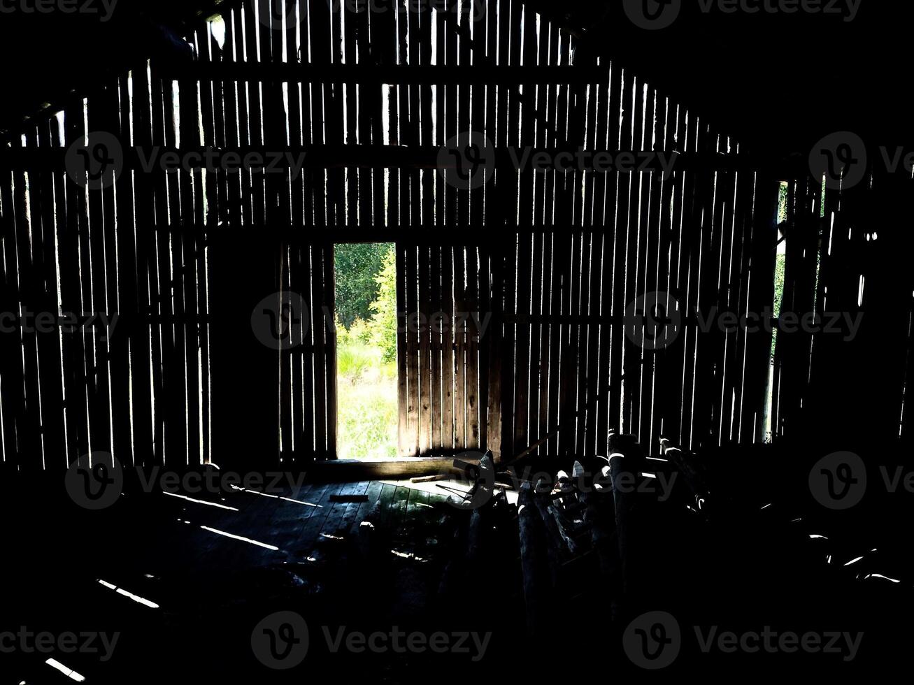Light shining through gaps in the wall of an old barn photo