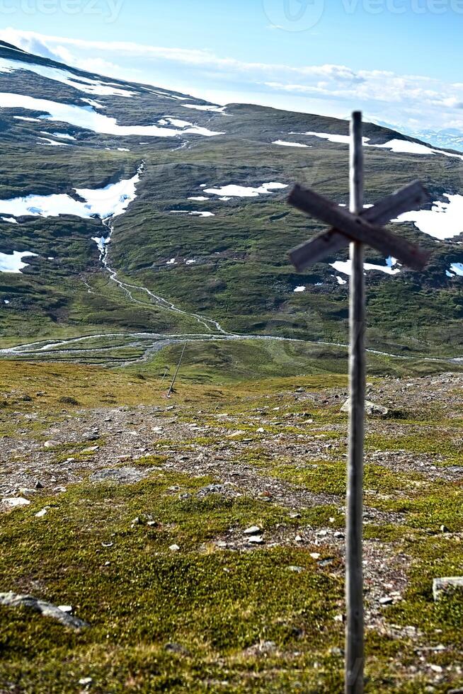 A marked trail on the barren plains near mount Nuolja, Lapland. The stream Gohpasjohka can be seen in the valley photo