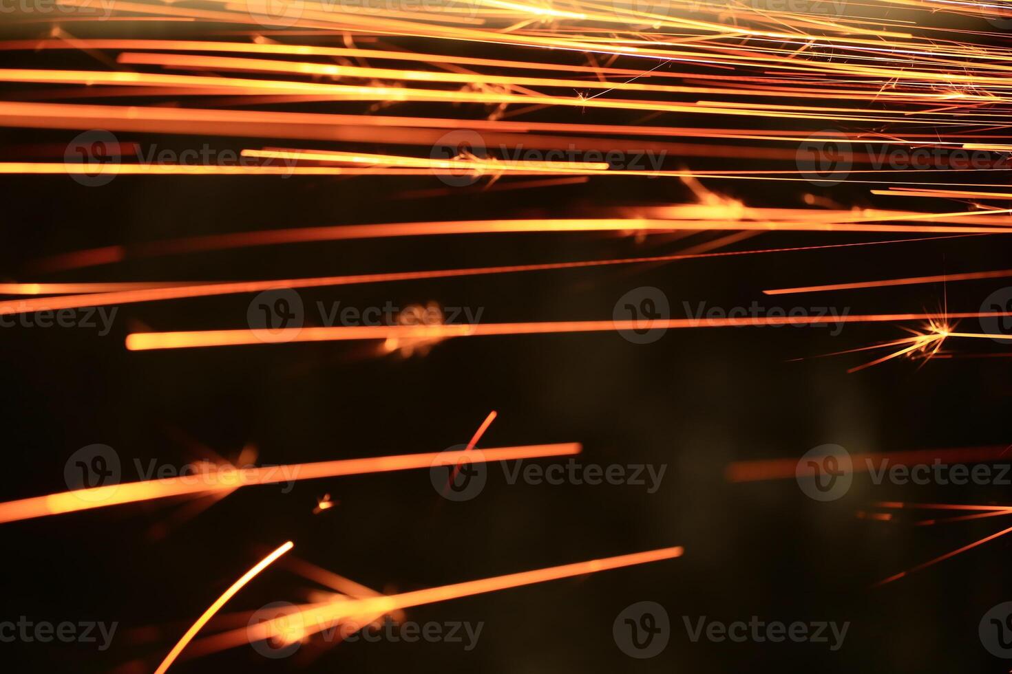 Spraying sparks from metalworking on a dark background photo