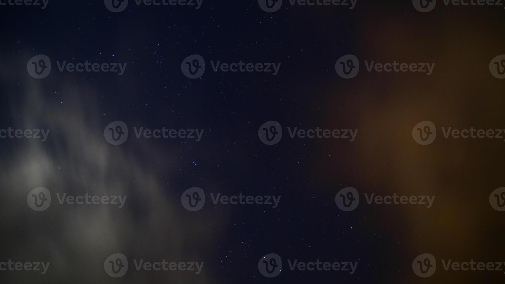 Long exposure of moving clouds on starry sky photo