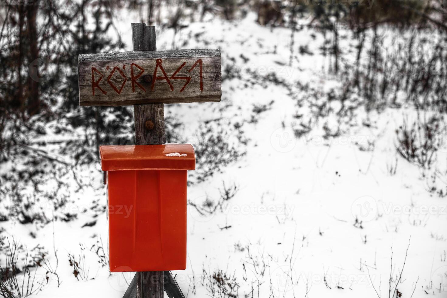 Archaic street sign with a red mailbox in snow photo