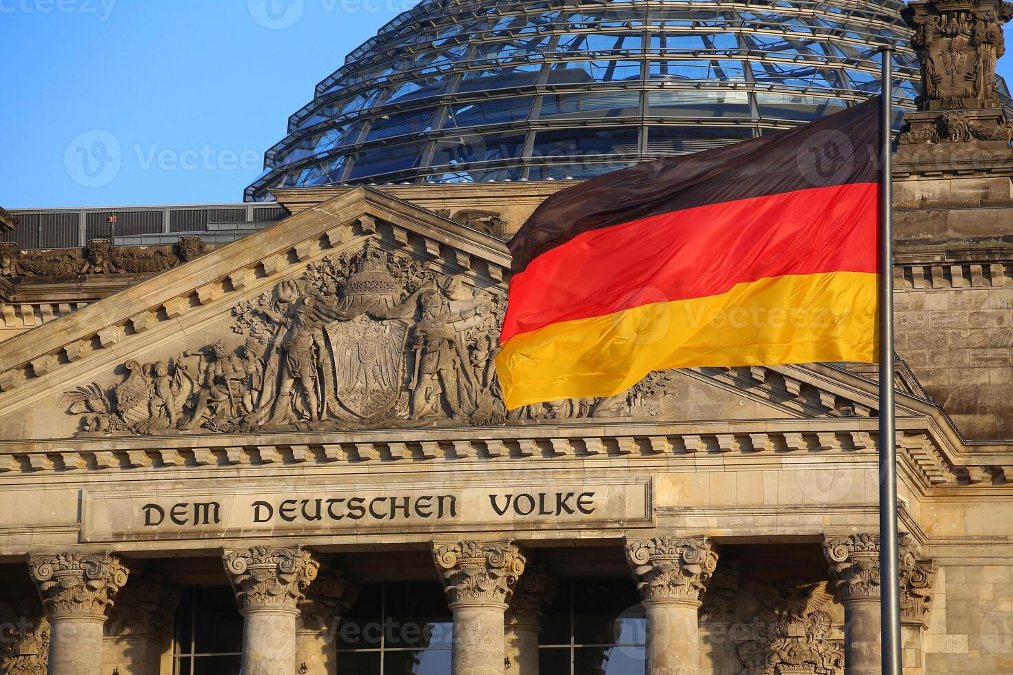 The German flag in front of the Reichstag building in Berlin. The inscription says Dem Deutschen Volke - To the German people photo