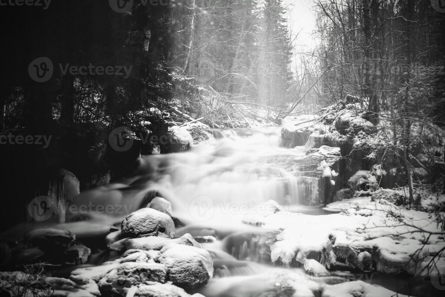 Moody long exposure shot of cascades in the small river Jaran in Bispgarden, Sweden. Light beams are coming from above photo