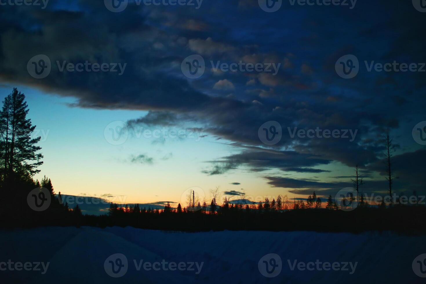 Dusk and clouds over winterly road in Swedish Lapland photo