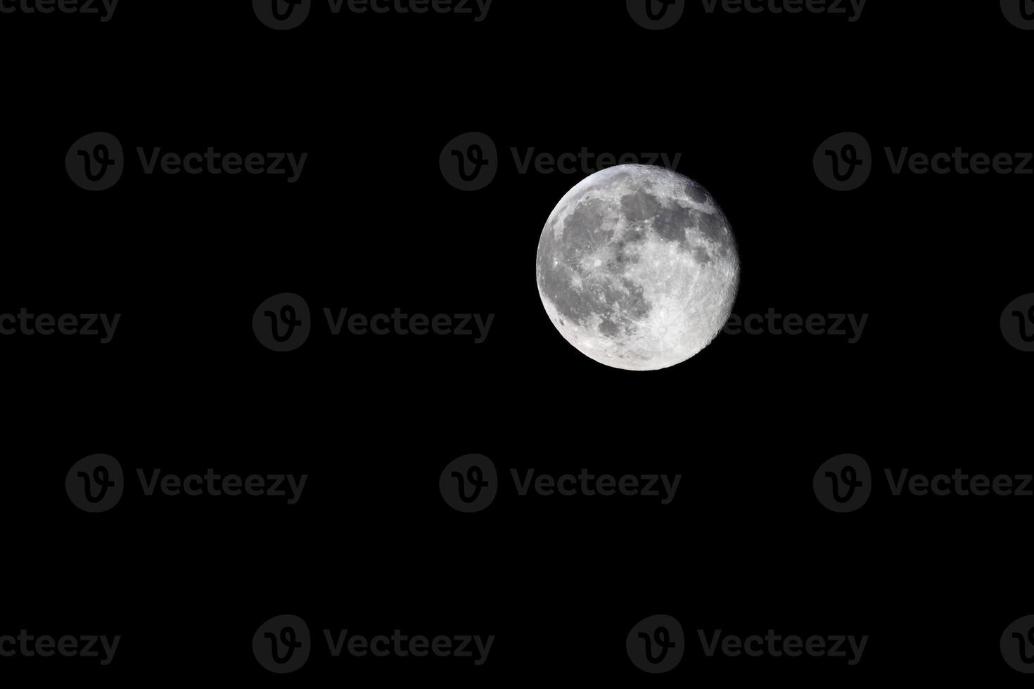 Waning gibbous, nearly full, moon on black background photo