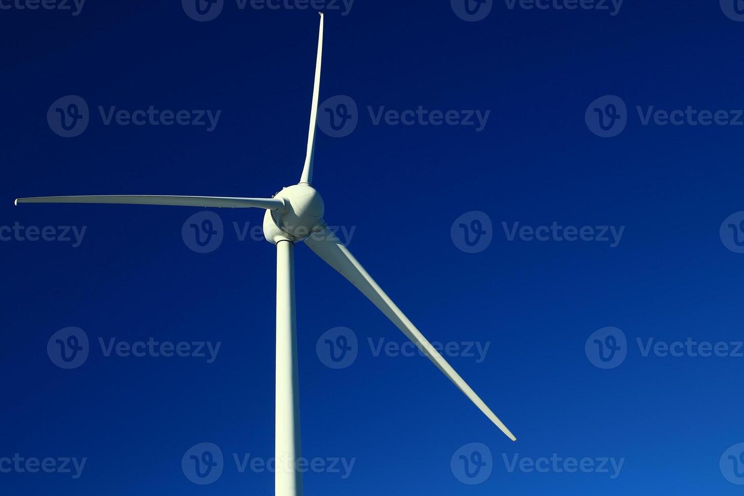 Single wind turbine on dark blue sky photo