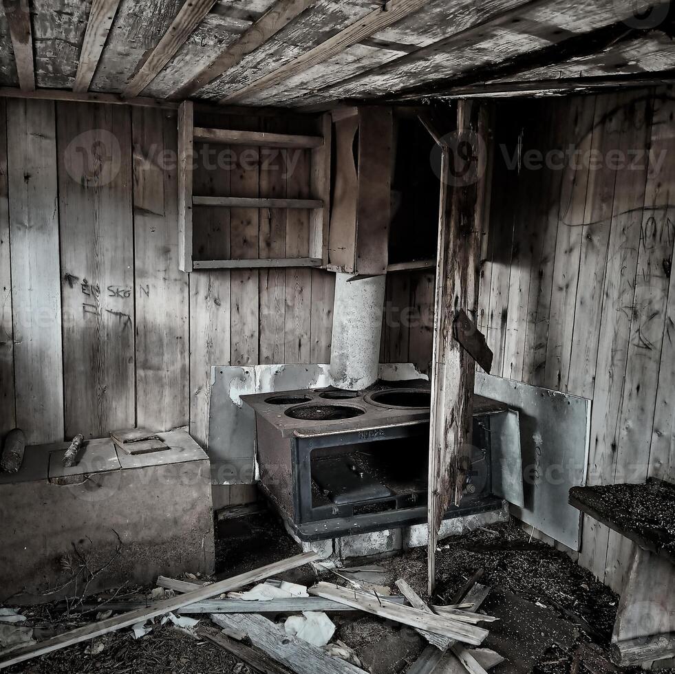 Interior of an abandoned hut with ruined stove photo