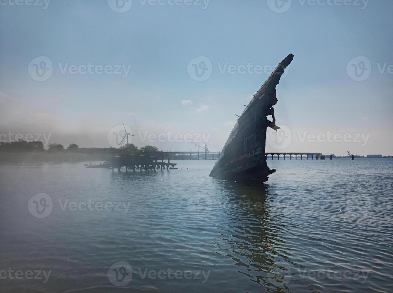 Old ship wreck in shallow water and mist photo