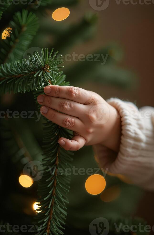 Child beautiful decorates the Christmas tree, hands close up, spruce branches and balls photo